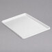 A white rectangular Channel plastic platter on a gray surface.