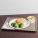 A Cambro taupe dietary tray with a plate of food and a drink.