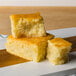 A stack of cornbread on a wood cutting board.