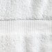 A close up of a white Oxford Belleeza bath towel with a white stripe.