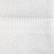 A close up of a white Oxford Belleeza bath towel with a stripe.