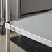 A Metro flat galvanized solid shelf with metal rods.
