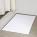 A white Oxford Platinum bath mat with a dobby twill hem on a tile floor.