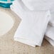 A stack of Oxford Platinum white wash cloths on a counter.