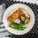 A Oneida cream white china plate with food on a table.
