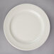 A Oneida Espree cream white china plate on a gray surface.