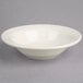 A Oneida cream white china fruit bowl with a rim on a gray surface.