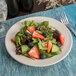 A Oneida cream white china plate with a salad of strawberries and blueberries.