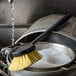 A Carlisle yellow Sparta utility brush scrubbing a pot.