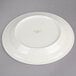 A white Oneida Espree china plate with green writing on it.