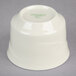 A white Oneida China bouillon cup with green text on it.