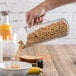 A hand pouring cereal into a Frilich acrylic dry food flute over a glass container.