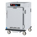 A white Metro C5 heated holding cabinet with a solid door on wheels.