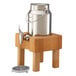 A Frilich stainless steel milk dispenser on a beech wood stand.