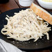 A plate of Napoli linguine pasta with bread.