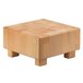 A beech wood cube riser with legs.