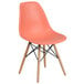 A Flash Furniture peach plastic chair with wood legs.