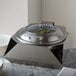 A Rosseto stainless steel round chafer with a lid on a counter.