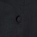 A close up of a black Chef Revival chef coat with buttons.