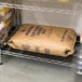 A brown bag of Morton Coarse Kosher Salt on a shelf with other bags of flour.