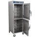 An Alto-Shaam stainless steel holding cabinet with Dutch doors open and universal racks inside.