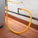 A yellow Regency gas connector hose connected to a black pipe.