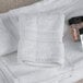 A white Oxford Reserve washcloth with a bottle of liquid on it.