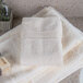 A stack of white Oxford Vicenza Avorio wash cloths on a counter.