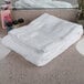 A stack of white Oxford Reserve bath towels on a counter top.