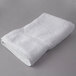 An Oxford Regale white bath towel folded on a gray surface.
