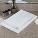 An Oxford Bronze white bath towel on a counter.