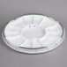 A white plastic Wilton cake turntable with green trim.