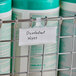 A Metro qwikSIGHT label holder attached to a metal rack with a label for disinfectant wipes.
