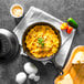 A Lodge cast iron skillet of macaroni and cheese with cheese and parsley on top.