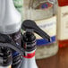 A Monin black plastic pump on a white Monin bottle of concentrated flavoring syrup.