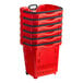 A stack of red plastic grocery market shopping baskets with wheels and black handles.