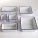 A group of white and blue speckled rectangular American Metalcraft serving bowls.