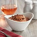 An Acopa bright white porcelain coupe bowl filled with chocolate pudding on a table.