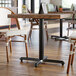 A Lancaster Table & Seating black cast iron table base on a table in a restaurant.