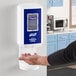 A person using a Purell automatic waterless hand sanitizer dispenser.