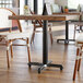 A Lancaster Table & Seating black column table base on a table in a restaurant.