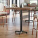 A Lancaster Table & Seating black cast iron bar height table base with a black pole.