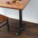 A Lancaster Table with a black cast iron end column table base on it.