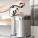 A person using an Edlund heavy duty manual can opener to open a can.