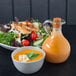 A bowl of salad with a leafy green garnish on a table.