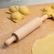 A Fox Run beech wood rolling pin on a table with ravioli.