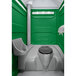 A PolyJohn portable restroom with a translucent top in a green and white bathroom.