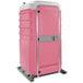 A pink PolyJohn portable restroom with a silver handle.