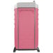 A pink and white PolyJohn portable restroom.