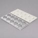 A white metal tray with 10 holes.